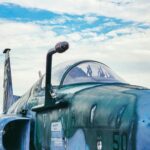 Close-up of a military jet aircraft against a vivid blue sky in São Paulo, Brazil.